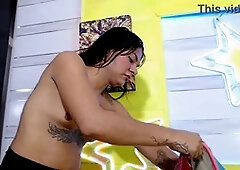 Stunning transsexual Ts Angelique with long hair and colored lenses pleasures herself