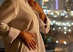 Transgirl in White Shirt Poses by City Window