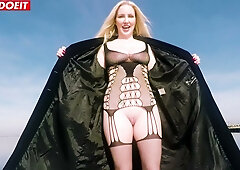 Blonde in fishnet lingerie takes her lover's cumshot on the beach