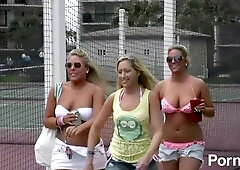 Bikini-clad women tease and mingle at a lively beachside party