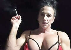 Kandy dominates in a red bikini top, built body glistening whilst holding lengthy white cigarettes. This babe takes drags with her hands held high, bl