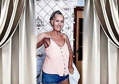 Over a cup of morning coffee, a happy aged woman enthusiastically teases her admirers with her tanned, gracious body, lengthy legs, big natural tittie