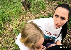 Two Girlfriends Suck Cock in the Wood