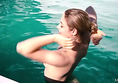 MILF brunette Kat Arina enjoys a sunny pool day in a blue swimsuit