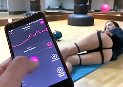 Athletic brunette gets her muff stimulated by remote vibrator in gym solo