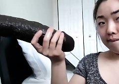 Naughty Asian camgirl with nice tits sucks a huge black toy