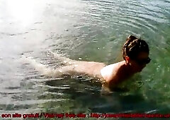 The bushy older exposed porn star is swimming and pissing outside, standing in front of the camera.