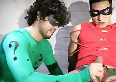 The riddler humiliates Robin and strokes his cock