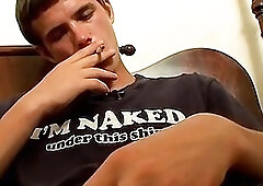 Inked gay dude smoking solo before stroking his big schlong