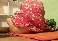 Indian woman with small breasts bends over on an orange mat at home
