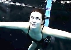 Beautiful girl swims and smiles underwater