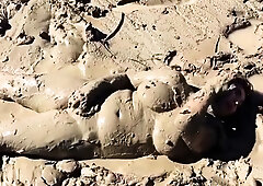 Curvy cougar covers herself in mud and masturbates outdoors