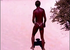Suntanned boy on beach in little strap g-string temporarily