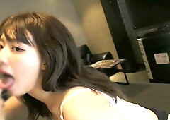 Mature Asian woman explores intimacy with a man in a private bedroom setting