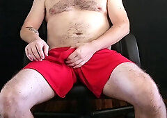 Guy Plays With Cock Through Gym Shorts Before Pulling It Out To Cum