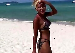 At the beach an Asian shemale sheds her bikini and jerks off