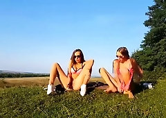 Naughty young lesbians masturbate together in the outdoors
